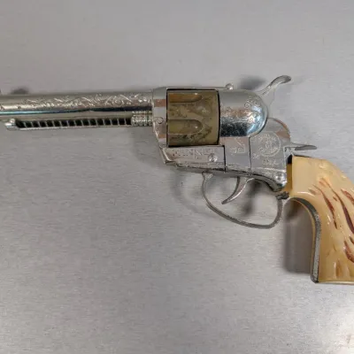 Sale Photo Thumbnail #304: Vintage Mattel Fanner 50 die-cast toy cap gun featuring engraved chrome metal finishing and faux stag horn grips.