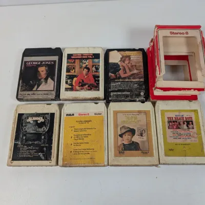 Sale Photo Thumbnail #93: Collection of seven vintage 8-track tapes featuring artists like George Jones, Conway Twitty, Alabama, Elvis Presley, and The Beach Boys, accompanied by a damaged Stereo 8 original box.
