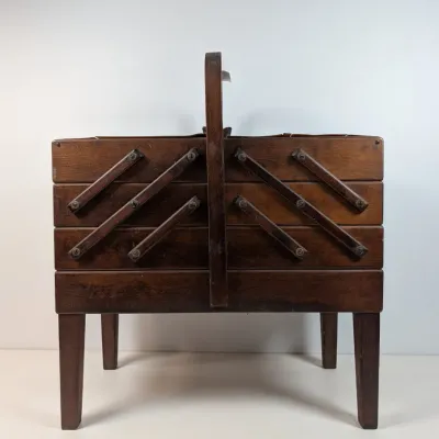 Sale Photo Thumbnail #59: Vintage mid-century wooden cantilever sewing box with four tapered legs and a top carrying handle.