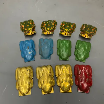 Sale Photo Thumbnail #277: Collection of twelve vintage tin litho frog clicker noisemakers, including spotted, solid blue, green, yellow, and red designs with light finish wear.
