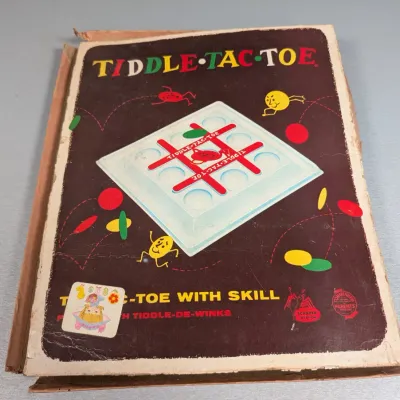 Sale Photo Thumbnail #307: Vintage Tiddle-Tac-Toe board game by Schaper, featuring colorful retro box art with wear along the edges.