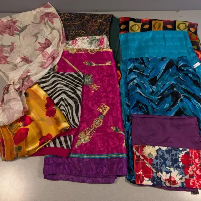 Sale Photo Thumbnail #153: Collection of assorted vintage scarves in various colorful prints, including floral, paisley, zebra stripe, and geometric patterns.