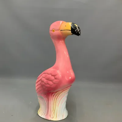 Sale Photo Thumbnail #286: Vintage painted ceramic or blow-mold flamingo garden figure, featuring a bright pink body and yellow beak with minor wear to the paint.
