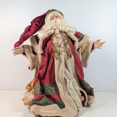Sale Photo Thumbnail #54: Vintage-style Santa Claus figure dressed in a elaborate fabric coat with faux fur trim, gold cord details, and a long pointed cap.