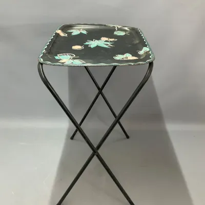 Sale Photo Thumbnail #266: Vintage mid-century folding metal TV tray table with a black tray top featuring turquoise and beige floral graphics.
