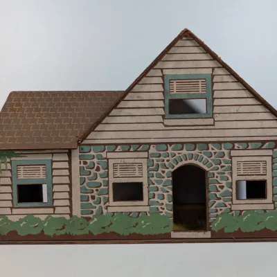 Sale Photo Thumbnail #421: Vintage Rich Toy Company pressed cardboard dollhouse featuring a lithographed stone and siding facade, circa 1930s to 1940s.