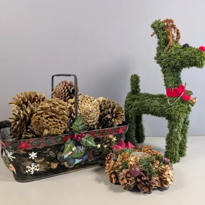 Sale Photo Thumbnail #151: Festive Christmas decor set featuring a decorative wire basket filled with gold pinecones, a small pinecone wreath, and a faux-topiary standing reindeer figure with a red collar and bell.