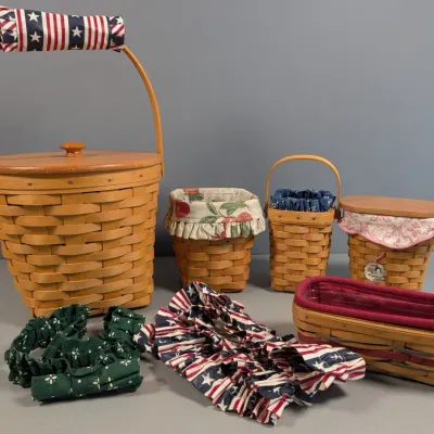 Sale Photo Thumbnail #116: Collection of Longaberger woven wood baskets featuring fabric liners, wooden lids, and patriotic accessories.