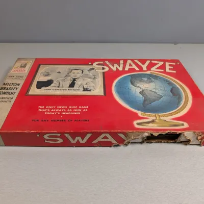 Sale Photo Thumbnail #202: Vintage 1950s Milton Bradley 'Swayze' news quiz board game, featuring John Cameron Swayze, showing noticeable edge wear and tearing on the side of the box lid.