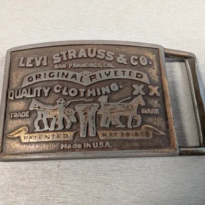 Sale Photo Thumbnail #163: Vintage Levi Strauss & Co. metal belt buckle featuring the iconic two-horse logo and embossed text.