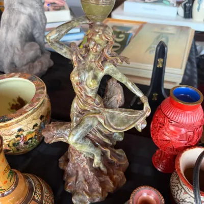 Carved green soapstone figurine of a dancing water bearer woman, surrounded by various Asian and Southwestern decorative ceramics and art...