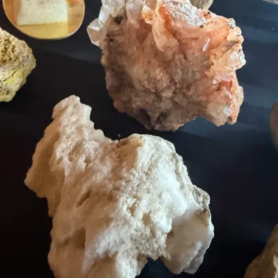 Collection of natural mineral specimens, featuring quartz clusters and raw rock formations.