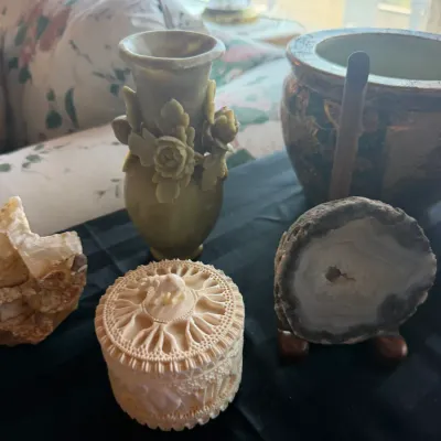 Collection of decorative Asian and natural items including an intricately carved round container, floral relief vase, polished agate...