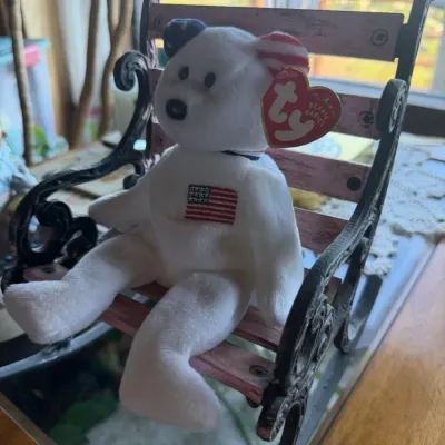 Ty Beanie Baby "Spangle" patriotic bear, featuring an embroidered US flag chest emblem and original swing tag attached, seated...