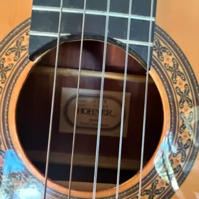 Close-up of a Hohner classical acoustic guitar soundhole, featuring an ornate mosaic rosette inlay and an internal maker's label.