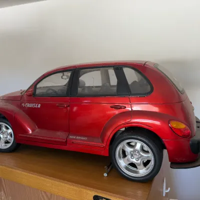 Large New Bright metallic red PT Cruiser toy car with chrome-finished wheels.