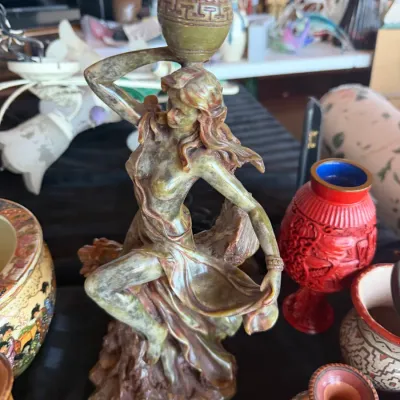 Carved composite or faux resin figurine of a classical water bearer, featuring muted green and brown tones.