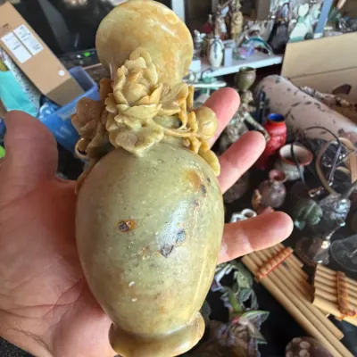 Hand-carved soapstone vase featuring intricately detailed floral embellishments around the neck.