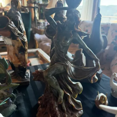 Carved stone statuette depicting a semi-nude classical female figure carrying a water vessel on her head.