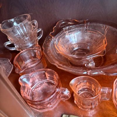 Sale Photo Thumbnail #335: Collection of vintage pink depression glass tableware, including creamers, sugar bowls, and a large serving bowl with molded geometric and floral patterns.