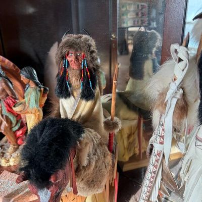 Sale Photo Thumbnail #199: Handcrafted Native American warrior doll mounted on a horse, detailed with real fur, leather garments, beaded accents, and a wooden spear.