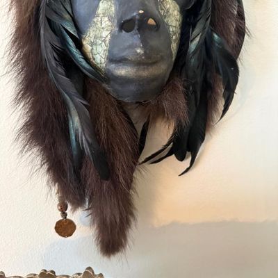 Sale Photo Thumbnail #211: Hand-painted ceremonial style wall mask decorated with natural fur trim, black feathers, and beaded accents.