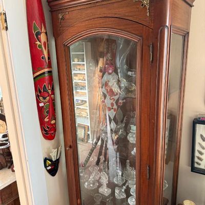 Sale Photo Thumbnail #257: Traditional mahogany curio display cabinet with a arched glass door, brass corner accents, and interior glass shelves filled with cut glass items.