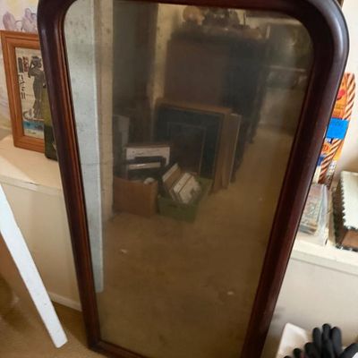 Sale Photo Thumbnail #174: Large vintage floor or wall mirror framed in dark stained rounded wood.