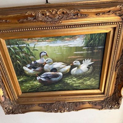 Sale Photo Thumbnail #46: Framed oil painting depicting ducks resting by a pond, set in an ornate carved gesso gold frame.
