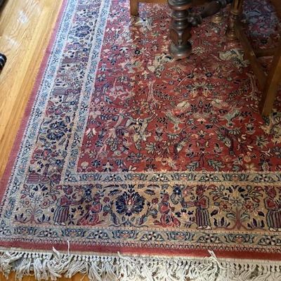 Sale Photo Thumbnail #149: Hand-knotted Oriental area rug featuring a pictorial hunting motif on a red field with intricate multi-band borders and white fringe.