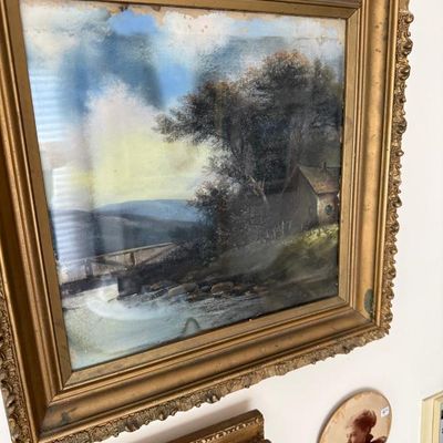 Sale Photo Thumbnail #86: Antique landscape painting depicting a cottage near a stream, housed in an ornate gilt gesso frame showing some age-related finish wear.