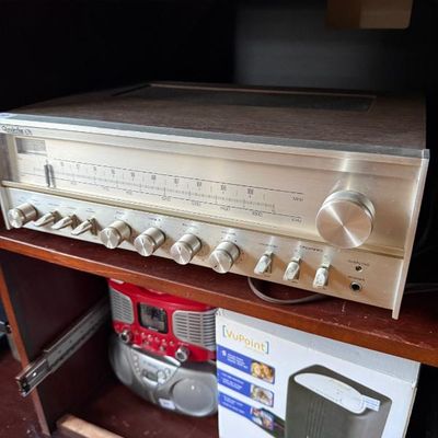 Sale Photo Thumbnail #190: Vintage Quadraflex 676 stereo receiver with silver faceplate and faux wood cabinet, sitting above a VuPoint digital scanner box and a portable boombox.