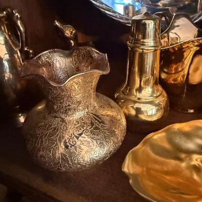 Sale Photo Thumbnail #348: Collection of brass decor, including an etched ruffled-edge vase, a lighthouse-style shaker, and a small scalloped dish.