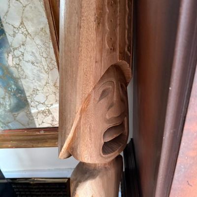 Sale Photo Thumbnail #271: Hand-carved mid-century wooden tiki figure featuring detailed facial expressions and textured headpiece.