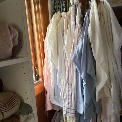 Sale Photo Thumbnail #239: Collection of men's vintage button-up dress shirts hanging in a closet organizer, including striped, solid white, and pastel colors.