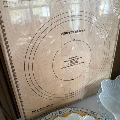 Sale Photo Thumbnail #364: KitchenAid 'Perfect Pastry' wooden pastry board featuring printed pie and tart measurement guidelines, appearing sealed in original plastic wrapping.