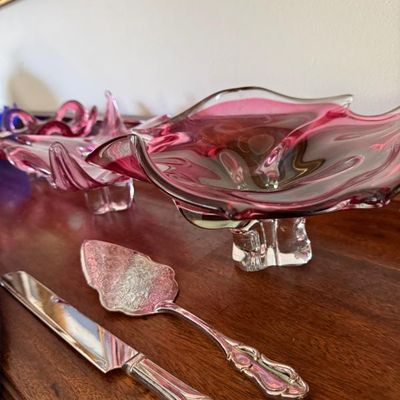 Sale Photo Thumbnail #154: Pair of vintage pink and clear art glass freeform bowls shown alongside a silver-plated cake knife and server set.