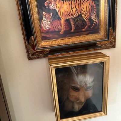 Sale Photo Thumbnail #105: Framed tiger print in an ornate gold and black vintage-style frame, hung above a shadow box frame containing a theatrical or decorative mask.