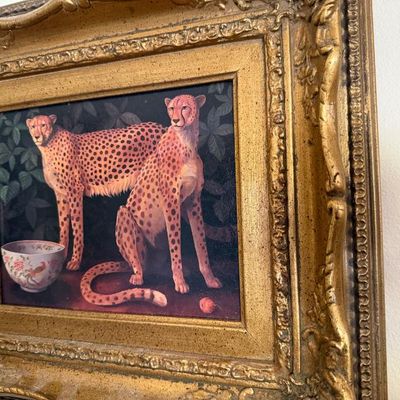 Sale Photo Thumbnail #104: Framed oil painting depicting two cheetahs alongside a porcelain bowl, housed in an ornate gilded Rococo-style frame.