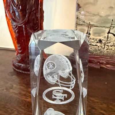 Sale Photo Thumbnail #353: Faceted crystal paperweight featuring 3D laser-etched San Francisco 49ers sports motifs, including a helmet, team logo, and player figure.