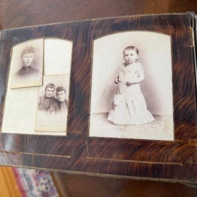 Sale Photo Thumbnail #288: Antique photo album page containing late 19th-century cabinet cards and tintypes featuring portraits of children and adults.