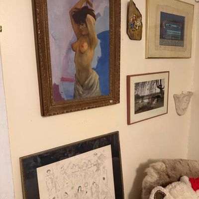 Sale Photo Thumbnail #119: Collection of framed art pieces, featuring a prominent vertical oil painting of a female nude in a carved wooden frame alongside various prints and decorative wall items.