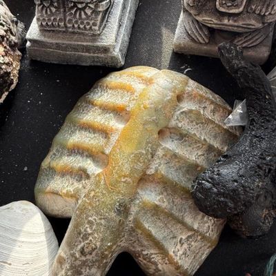 Sale Photo Thumbnail #144: Carved stone sculpture resembling a rib cage alongside other stone figurines and decorative artifacts.