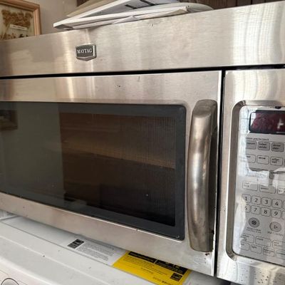 Sale Photo Thumbnail #366: Maytag stainless steel over-the-range microwave featuring a digital keypad control panel and heavy-duty handle.