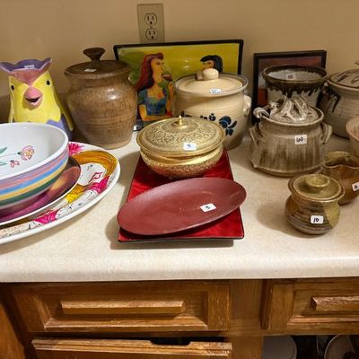 Sale Photo Thumbnail #167: Assortment of vintage studio pottery, ceramic bowls, covered crocks, and decorative brass kitchenware displayed on a countertop.