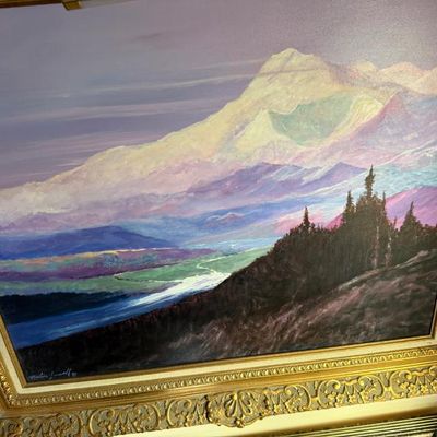 Sale Photo Thumbnail #71: Framed oil painting depicting a snow-capped mountain landscape at sunset, housed in an ornate gilt wood frame.