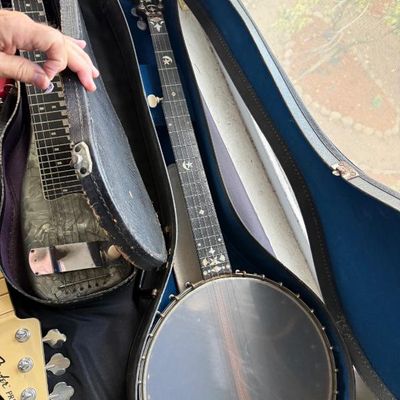Sale Photo Thumbnail #180: Vintage 5-string banjo with star and moon fretboard inlays inside a hard case, displayed alongside a lap steel guitar and a Fender Precision Bass headstock.