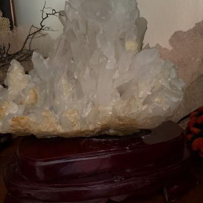 Sale Photo Thumbnail #133: Large clear quartz crystal cluster specimen, mounted on a carved dark wood display stand.