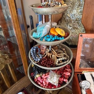 Sale Photo Thumbnail #32: Four-tiered metal tray filled with assortment of loose beads, jewelry components, and finished necklaces including turquoise, coral, and wood.