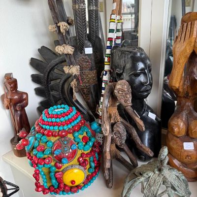 Sale Photo Thumbnail #227: Collection of African and Tribal artwork, including carved wooden busts, decorative spears, beadwork, a jeweled pot, and a metal crown.